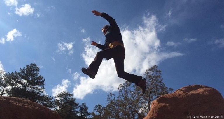 Scottish Gaelic consultant Àdhamh Ó Broin jumping across a rock