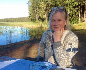 Filmmaker Erika Mikaelsson sittiing near a lake in the Swedish Laplands