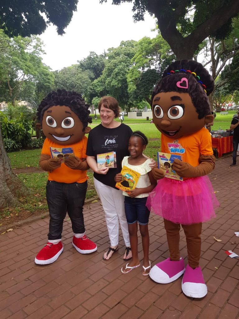 Julie Dakers posing with a girl at the launch of her children's book